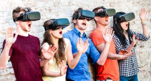 Surprised friends exploring metaverse on vr glasses – Virtual reality and wearable tech concept with happy people having fun together with headset goggles – Digital generation trends on bright filter